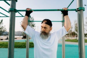 Image of bearded man grabbing pull up bar/  (Photo by cottonbro from Pexels)